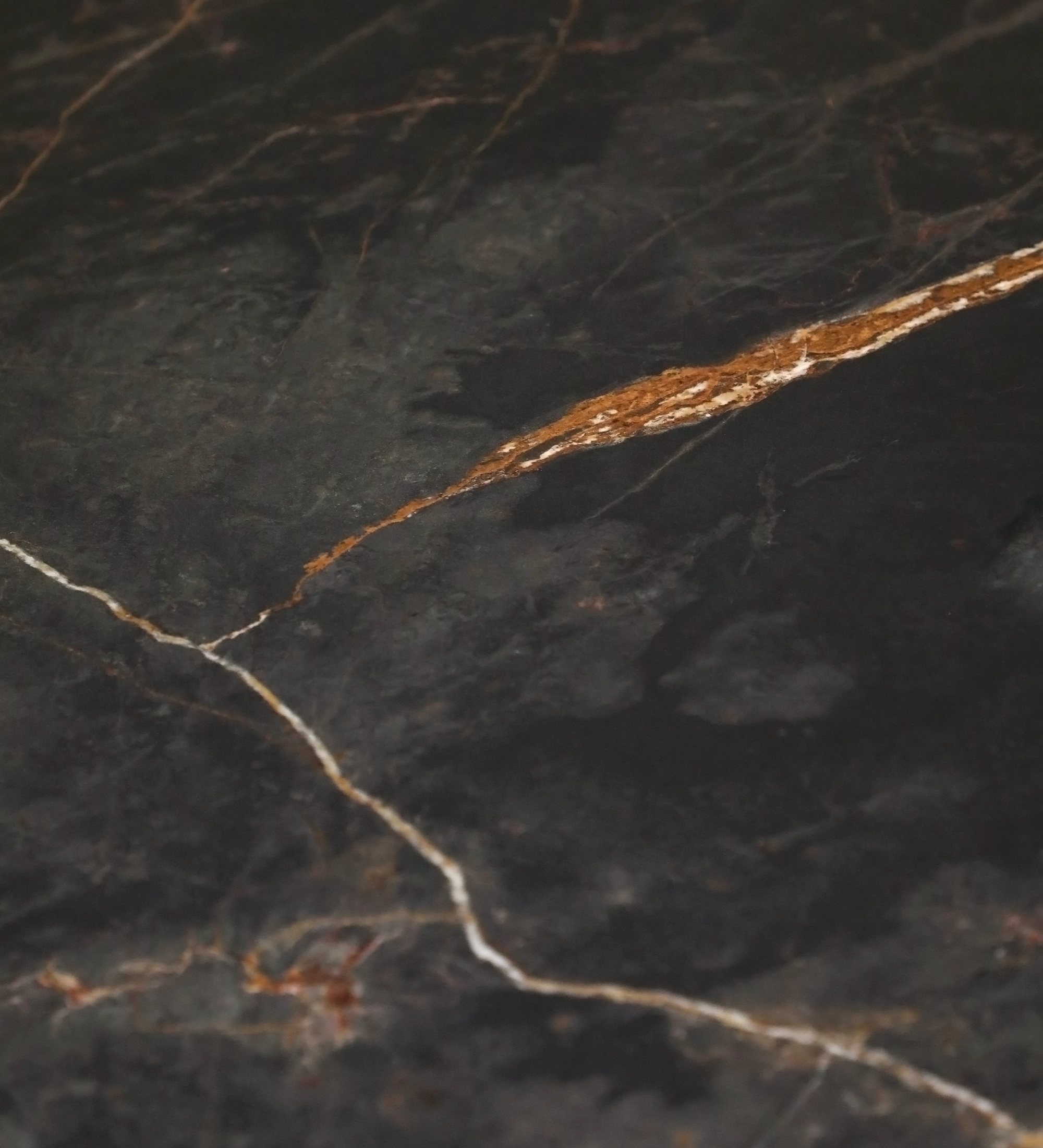 Lagos Dining Table close-up of black marble top with gold and white veining