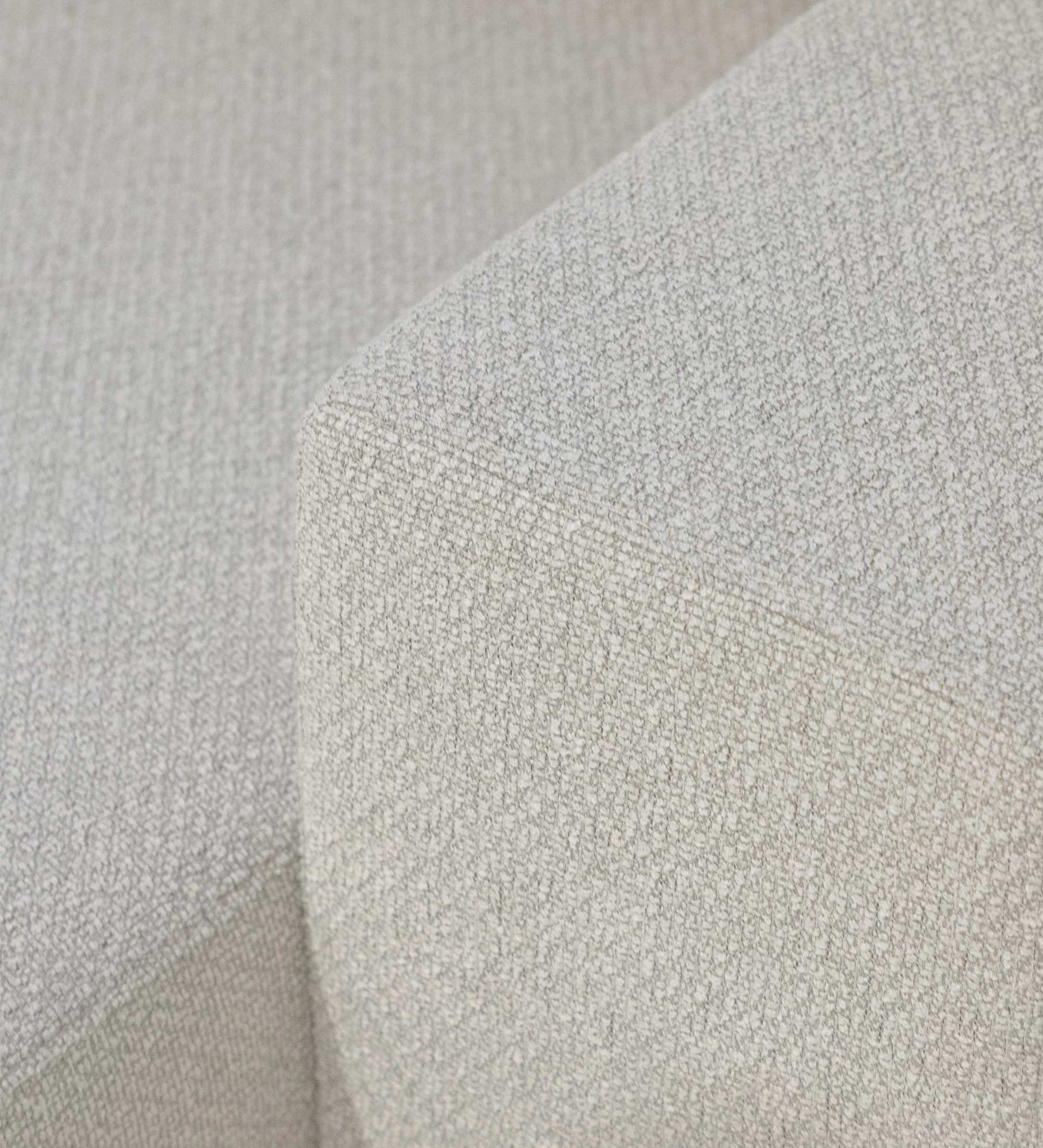 Detalle de tejido beige en esquina del sofá con chaise longue