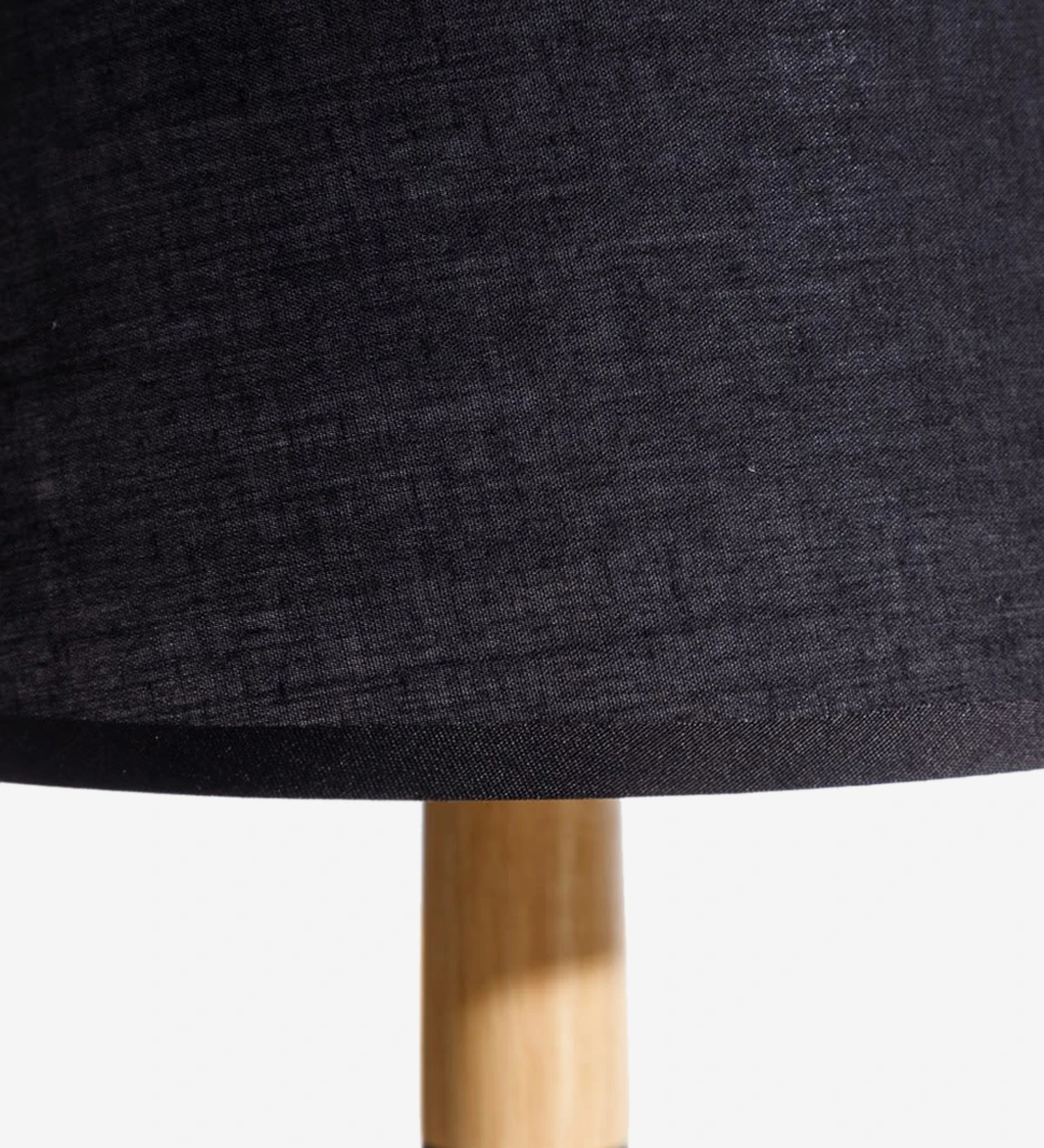  Lámpara de sobremesa con base de metal pintado de negro y madera con pantalla de tela negra.