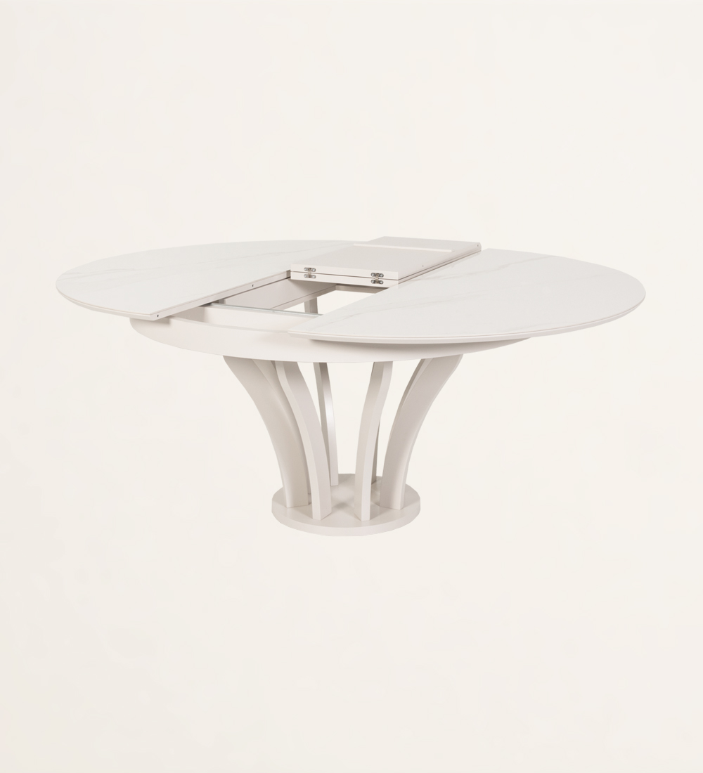 Mesa de comedor redonda extensible con tablero de cerámica y pie lacado perla.