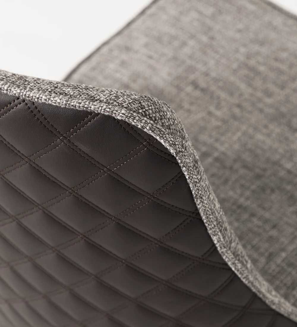 Silla tapizada en tejido, con pies lacados en negro.