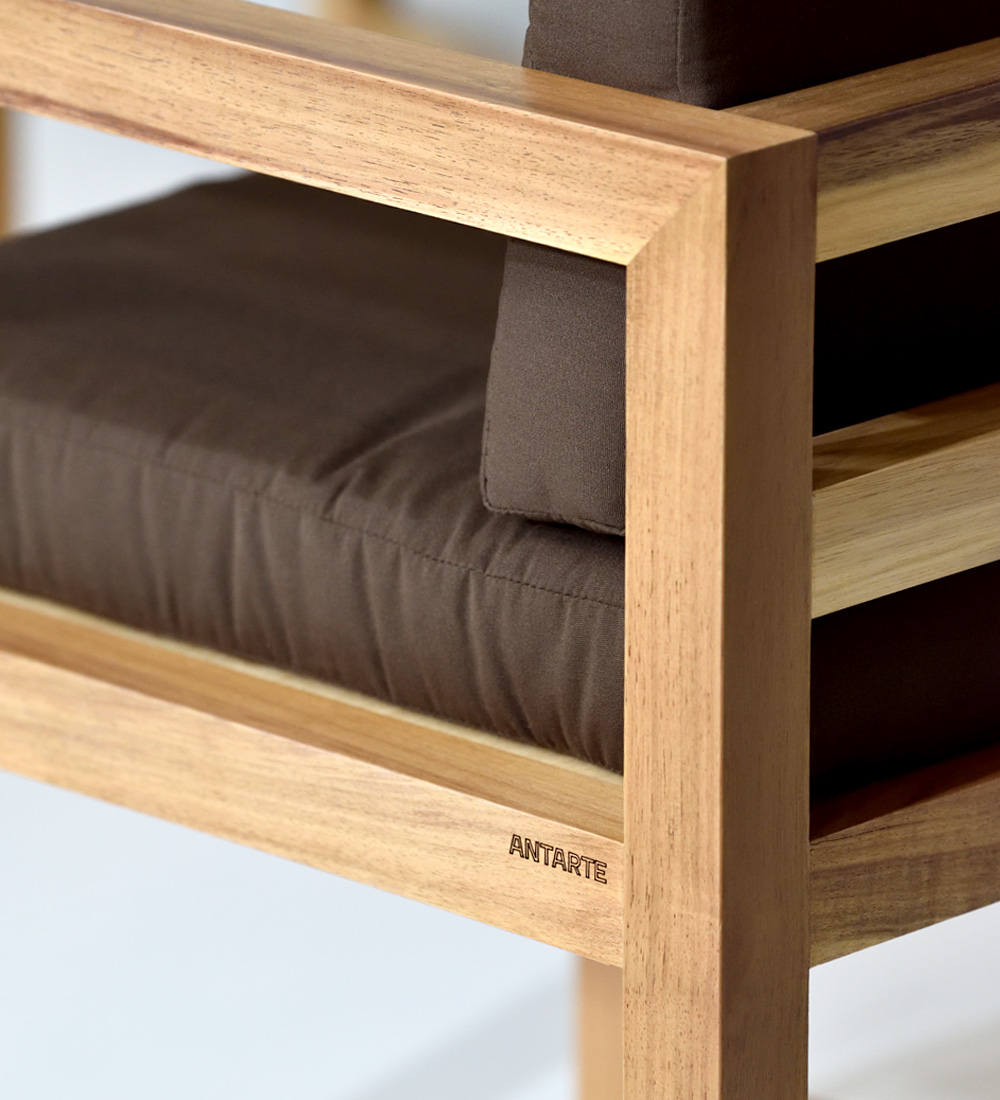 Cadeira com braços, almofadas estofadas a tecido e estrutura em madeira natural