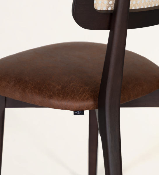 Chaise en bois, avec détails en rotin sur le dossier et assise recouverte de tissu.