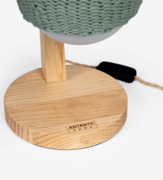 Candeeiro de mesa com estrutura em madeira e lâmpada com crochê em verde.