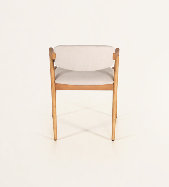 Chaise en bois de frêne couleur miel, avec assise et dossier rembourrés en tissu.