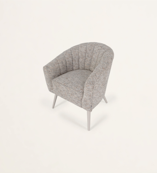 Sillón tapizado a tejido, pies lacados a perla.
