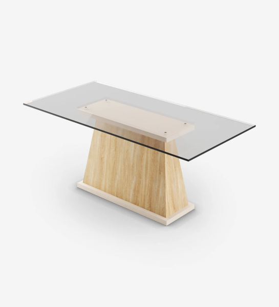Mesa de comedor rectangular con tablero de cristal, pie central en roble natural y base lacada perla.