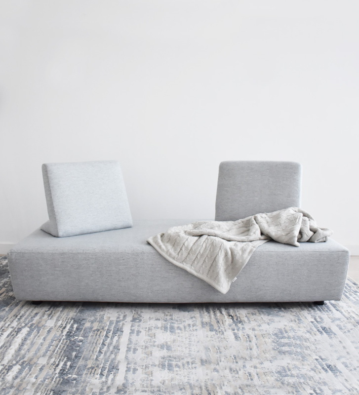 Canapé-lit, revêtu de tissu, avec coussins de dossier amovibles.