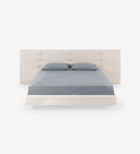 Lit double avec tête de lit à rectangles, recouvert de tissu, avec pied de lit suspendu.
