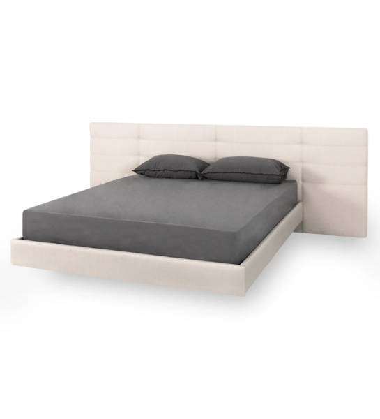 Lit double avec tête de lit longue, tapissée en tissu, avec panneau arrière suspendu.