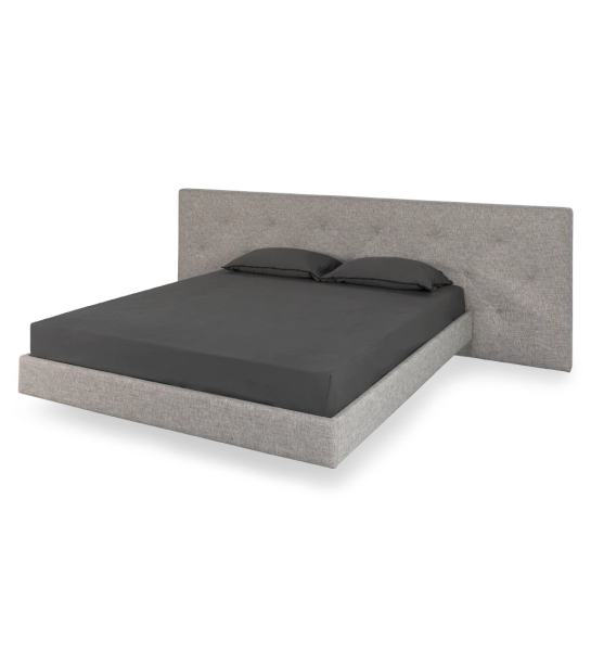 Double bed with headboard with rectangles, upholstered in fabric, with suspended footboard.