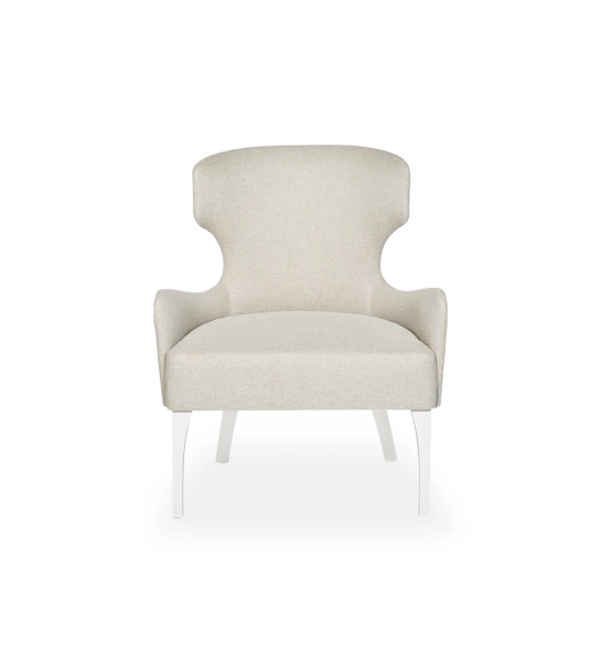 Sillón Pico tapizado en tela beige, tachuelas doradas, pies lacados perla.