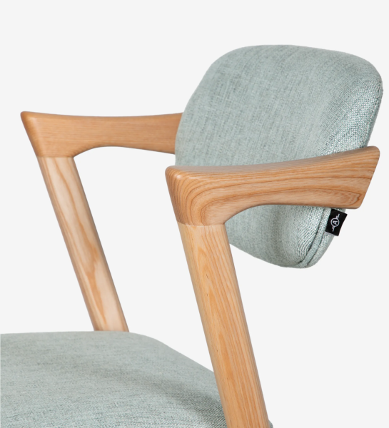 Taburete en madera de fresno color natural, con asiento y respaldo tapizado en tejido.