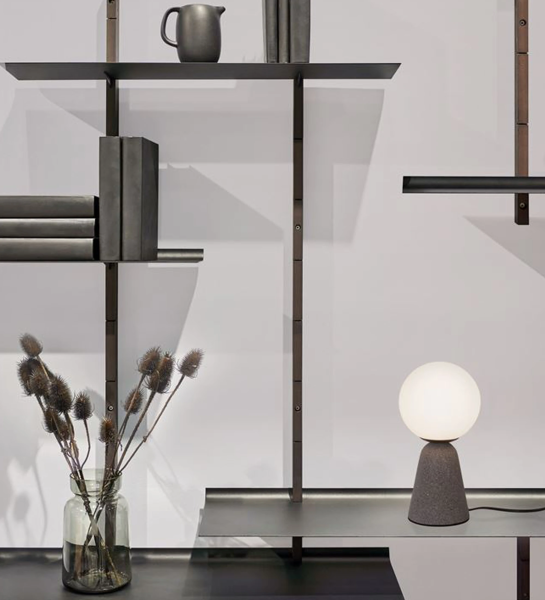Lampe de table avec base en béton gris et diffuseur en verre opale.