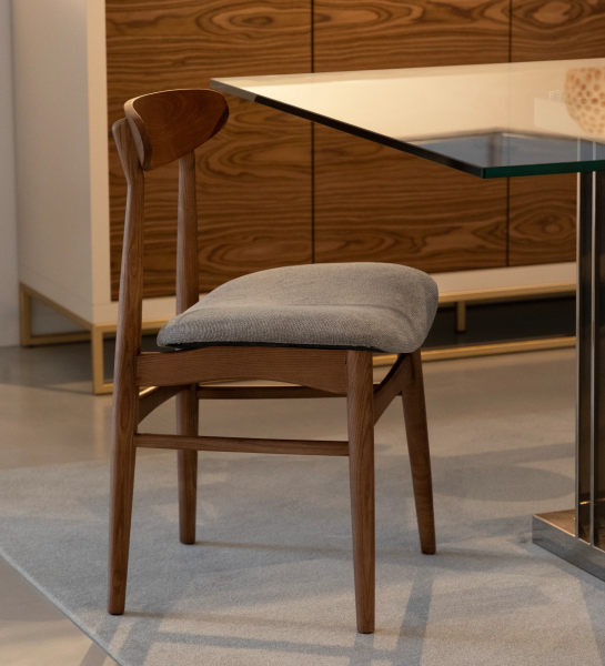 Chair with walnut wood structure and fabric upholstered seat.