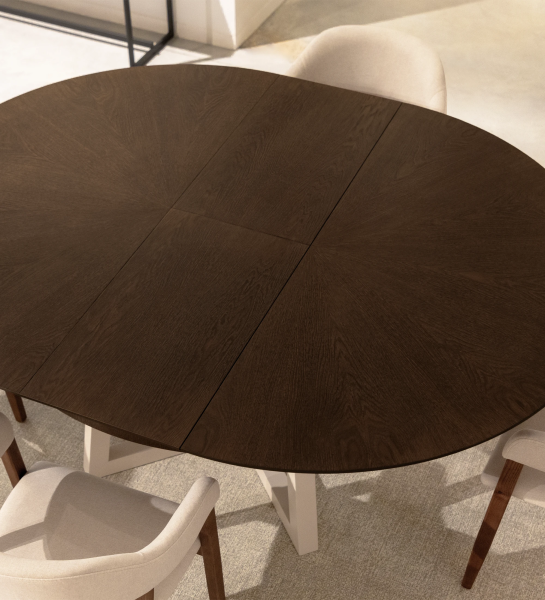 Table de repas ronde extensible avec plateau en chêne noyer et pieds laqués perle.