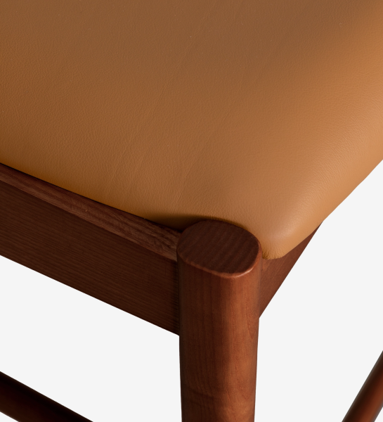 Taburete en madera de fresno color nogal, con asiento y respaldo tapizado en piel.