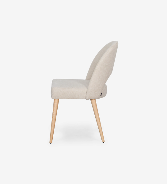 Chair upholstered in beige fabric, with natural colored wooden legs.