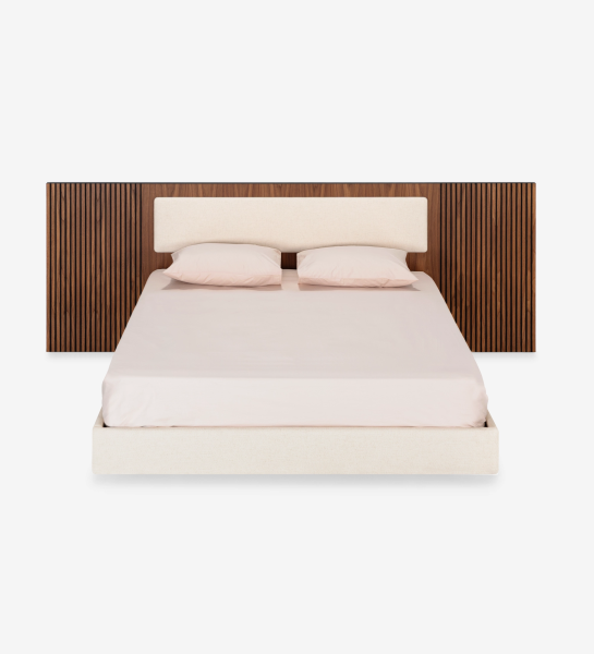 Cama doble con panel central del cabecero y base suspendida tapizados en tejido beige, laterales del cabecero con molduras de nogal natural.