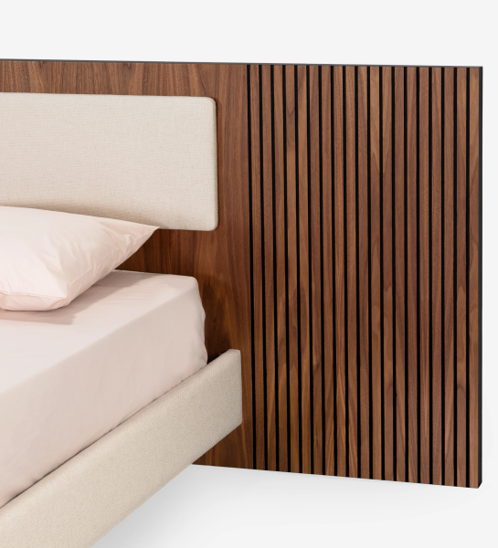 Cama doble con panel central del cabecero y base suspendida tapizados en tejido beige, laterales del cabecero con molduras de nogal natural.