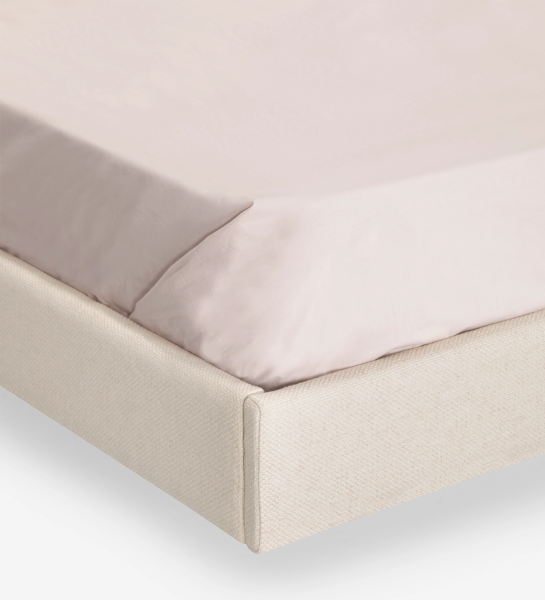 Cama doble con panel central del cabecero y base suspendida tapizados en tejido beige, laterales del cabecero con molduras de nogal natural.