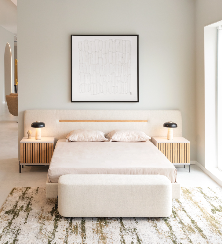 Cama doble con cabecero y base suspendida tapizada en tela beige, detallada en roble natural.
