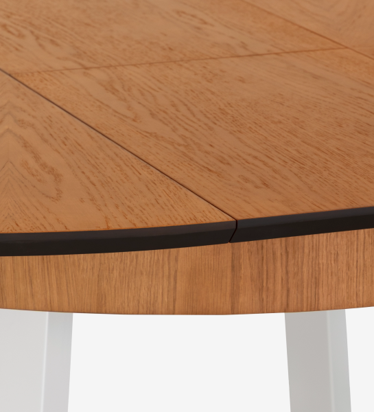 Mesa de comedor redonda extensible con tablero de roble miel y patas lacadas en perla.