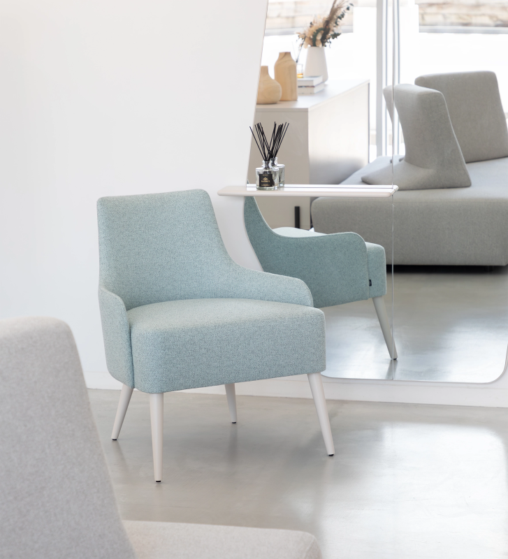 Fauteuil Oslo recouvert en tissu bleu, pieds laqués perle.