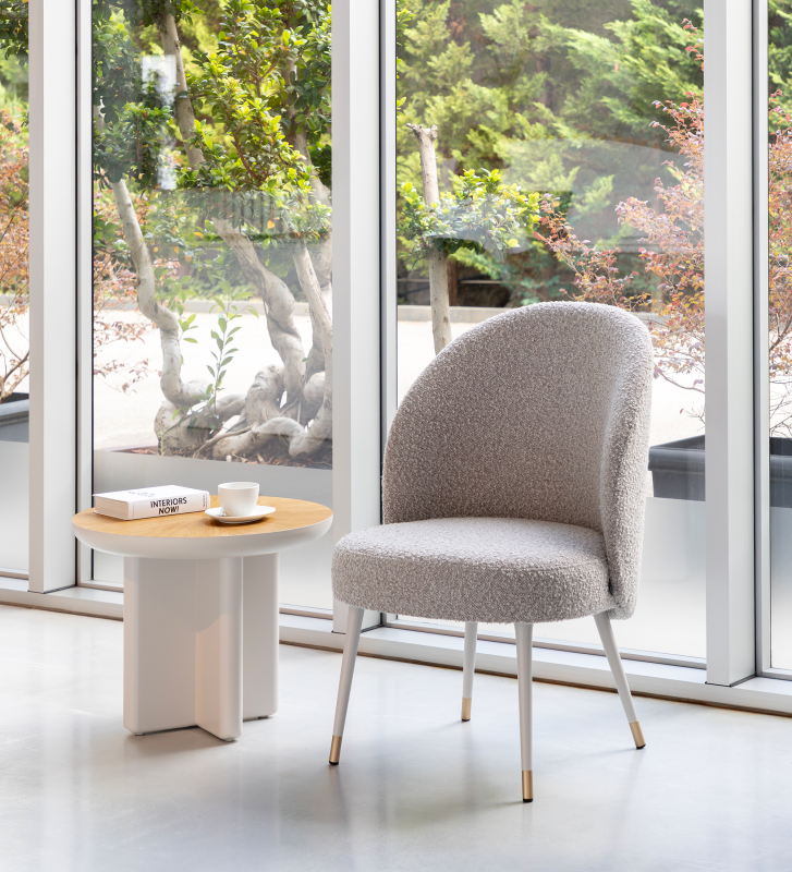 Fauteuil Geneve recouvert en tissu toffee, pieds laqués perle et détail doré.