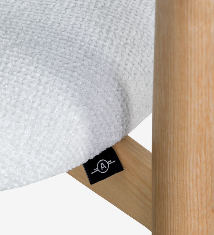 Taburete en madera de fresno en color natural, con asiento y respaldo tapizados en tela perla.