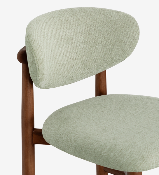Taburete en madera de fresno color nogal, con asiento y respaldo tapizados en tela verde.