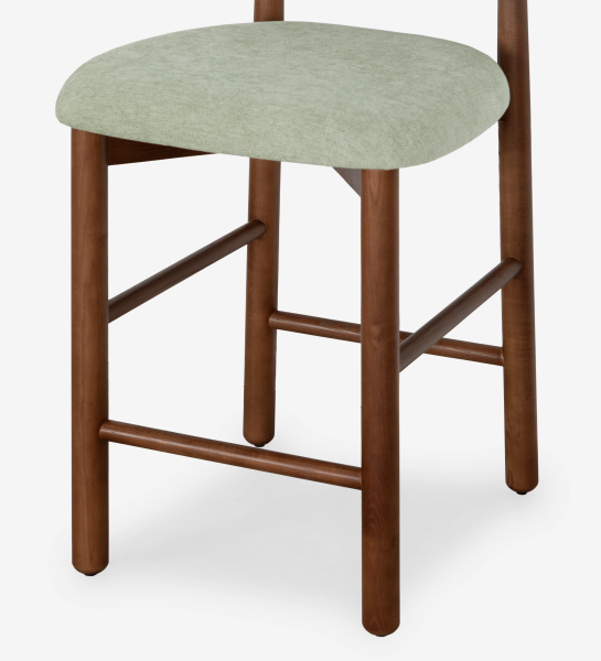 Taburete en madera de fresno color nogal, con asiento y respaldo tapizados en tela verde.