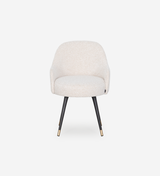 Silla giratoria tapizada en tejido perla con pies lacados en negro y detalles dorados.