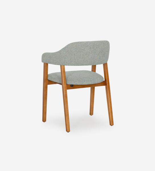 Chaise avec accoudoirs, en bois de frêne couleur miel, avec assise et dossier recouverts de tissu vert.