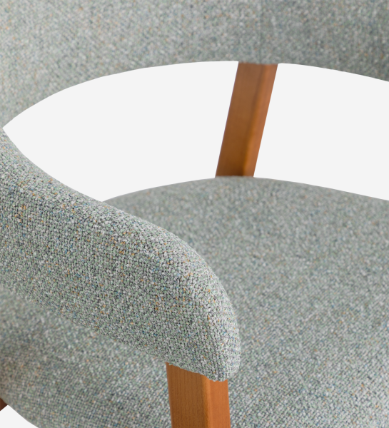 Chaise avec accoudoirs, en bois de frêne couleur miel, avec assise et dossier recouverts de tissu vert.