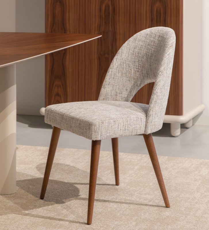 Chaise rembourré en tissu gris velouté, avec pieds en bois couleur noyer.
