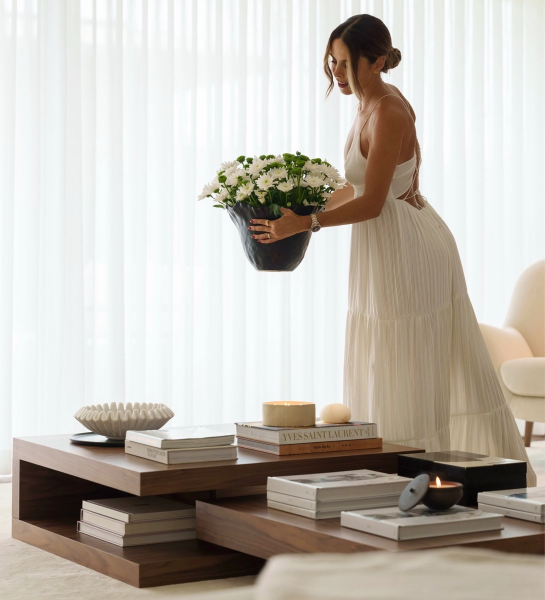 Conjunto Mesas de Centro Nice em madeira com mulher a colocar vaso de flores