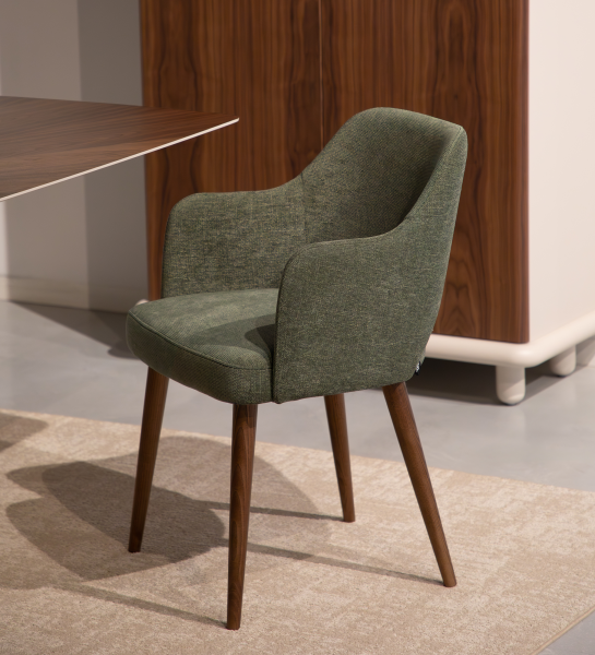 Silla Londres tapizada verde con brazos y patas de madera, sobre alfombra