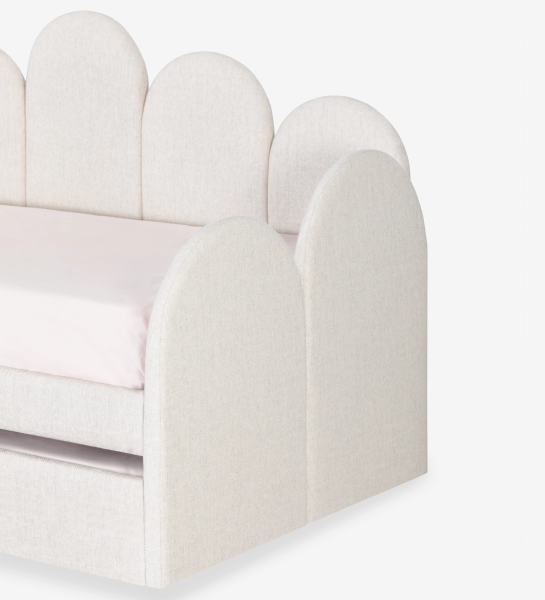 Lit de Divan avec structure et façade de tiroir rembourrées en tissu perle, avec lit dans le tiroir inférieur.