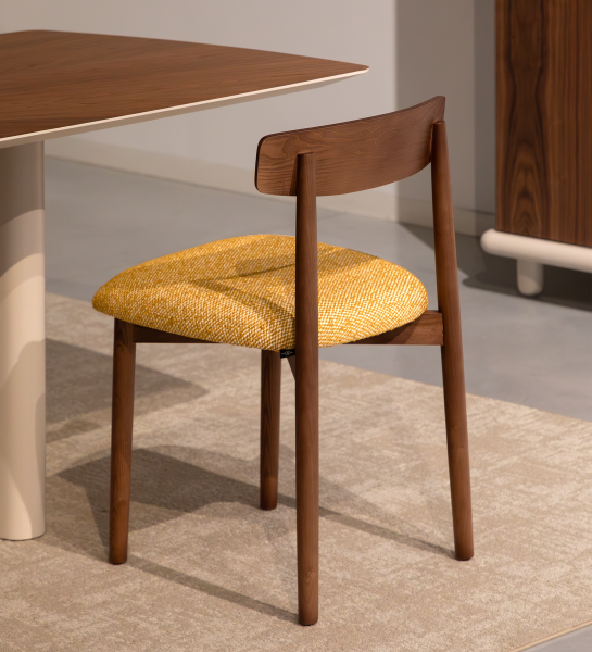 Silla de madera color nuez con asiento tapizado en tela amarilla