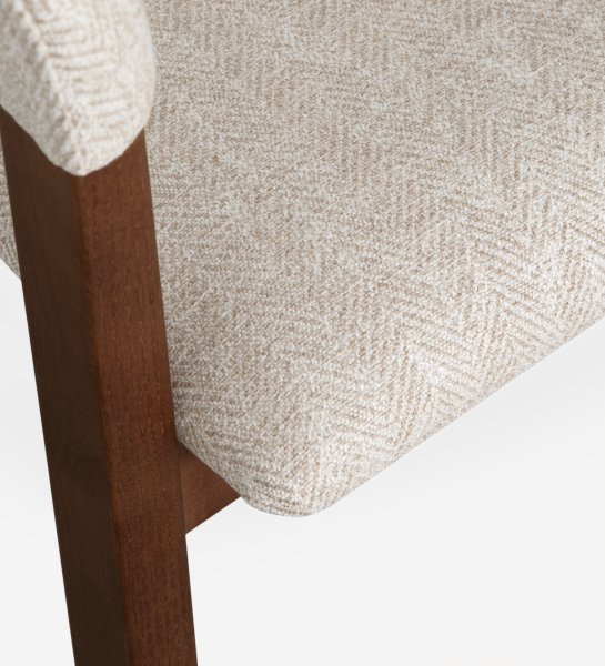 Chair with arms, in walnut-colored ash wood, with seat and back upholstered in beige fabric.