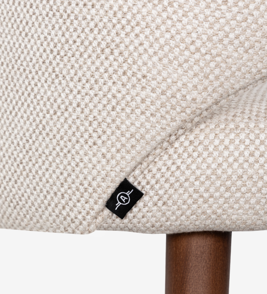 Cadeira com braços estofada a tecido de tons bege e pé em madeira cor nogueira.