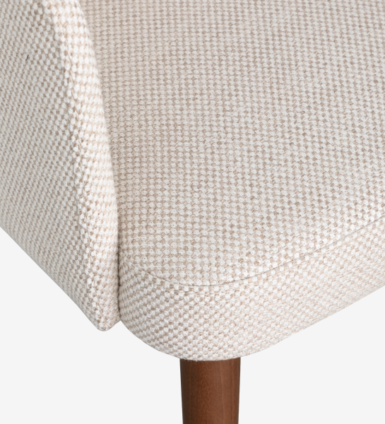 Cadeira com braços estofada a tecido de tons bege e pé em madeira cor nogueira.