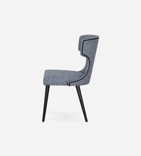 Cadeira Pico estofada azul-cinzento em perfil lateral com pernas pretas