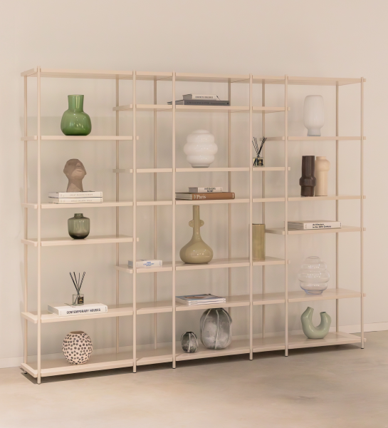 Bookcase Paris with open beige shelves displaying decorative vases, sculptures and books