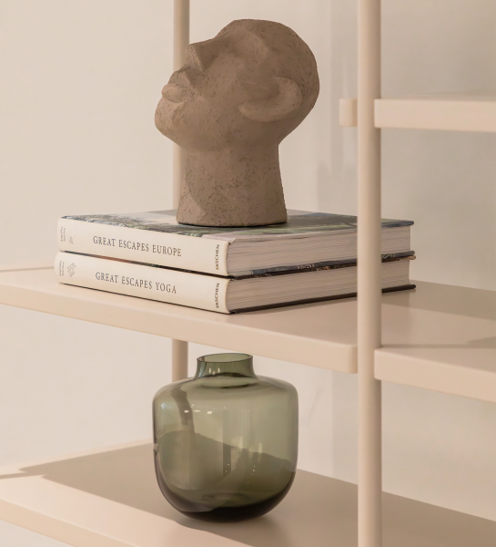 Bookcase Paris shelf with sculpted head on stacked books and green glass vase