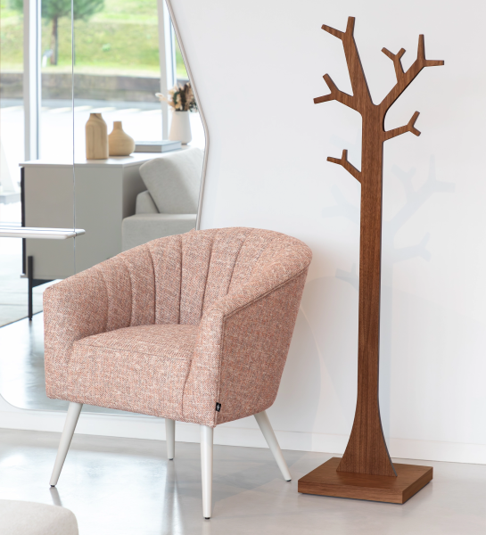 Simple Tree Hanger wooden tree-shaped freestanding coat rack beside pink armchair