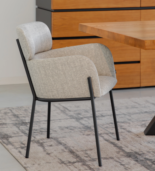 Silla Cannes tapizada gris claro con patas metálicas negras junto a mesa de madera