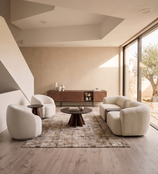 Mesa Auxiliar Lagos de madera junto a butaca en sala luminosa de tonos beige