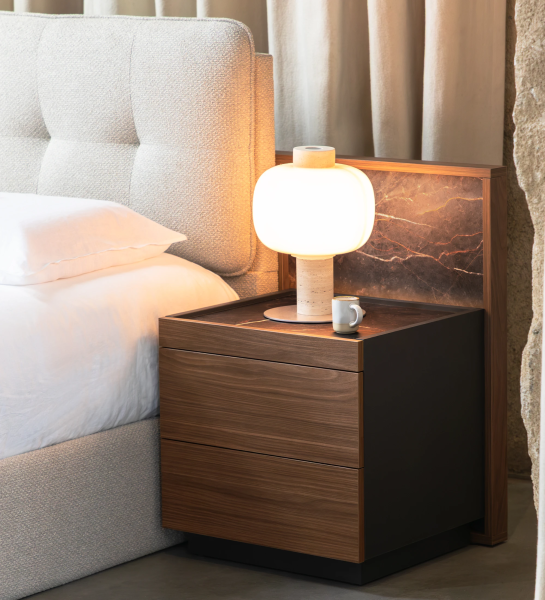 Mesita de Noche Lagos de madera con lámpara y taza junto a cama tapizada